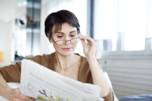 Woman reading a news paper with presbyopia
