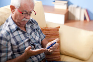 Elderly man checking his Blood Sugar with a Diabetes test